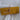 Plain mustard gold 100% cotton fabric folded and tied with twine on white fabric background