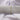 Plain silver grey 100% cotton fabric roll tied with twine on white cotton background