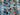 Fabric print featuring Xbox, Playstation, and Nintendo controllers on a blue background with spools of red and blue thread.
