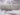 Plain silver grey 100% cotton fabric roll tied with twine on white cotton background