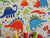 Dinosaur World Bright Colors on a Cream Background 100% Cotton - The Little Fabric Shop